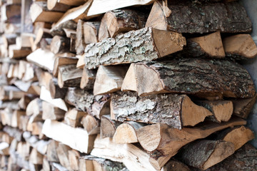 Woodpile of firewood by house. Chipped firewood laying. Preparation for winter. Close up.