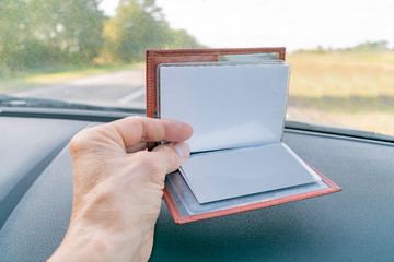 Purse with documents lying on the car panel