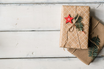 Stack of two wrapped giftboxes bound with threads on white table