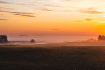Fototapeta premium Beautiful golden sunrise. Morning dawn with fog in the fall.