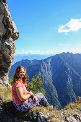 Naklejka premium Fabulously beautiful European cozy landscape in the cozy Alps mountains in Liechtenstein on the border with Austria. Young woman tourist in the mountains.