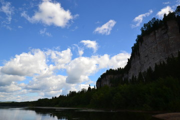 Fototapeta na wymiar Ural river Vishera calmly carries its waters along the stone foreheads of Mount Vetlan