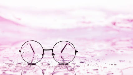 Tools for vision correction. Glasses and lenses with diopters on the background of splashes and...