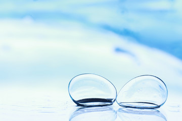 Tools for vision correction. Glasses and lenses with diopters on the background of splashes and blurry.