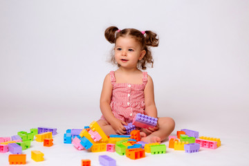 baby girl playing with multicolored constructor, isolate, space for text