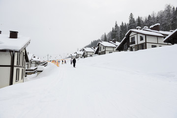 The holiday villas and slope with skiers in Bukovel ski resort, Ukraine