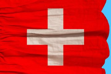 photo of beautiful colored national flag of modern state of Switzerland on textured fabric, concept of tourism, emigration, economy and politics, closeup