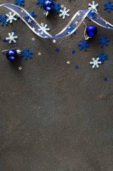 Blue Christmas background. Curly ribbon with decorative balls and snowflakes.