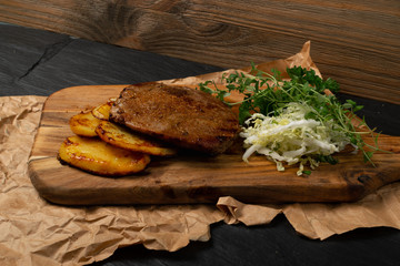 Grilled chivas beef steak with coleslaw, fried potatoes and greens