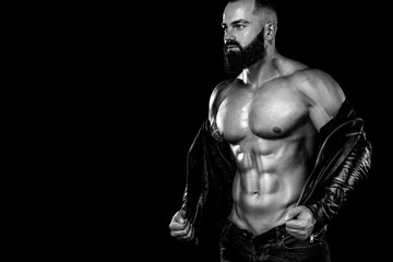 Men's fashion concept. Close-up portrait of a brutal bearded man topless in a leather jacket....