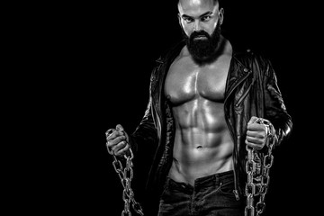 Men's fashion concept. Close-up portrait of a brutal bearded man topless in a leather jacket....