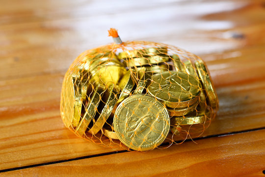 Gold wrapper on chocolate coins in a net wrap.