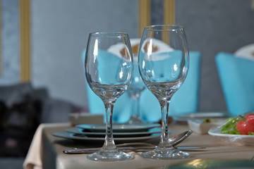 Part of interior . wine glasses on the table in front of the empty wineglass. Empty glasses set in restaurant.