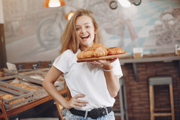 Girl at the bakery. Lady with cake. Blonde in a white shirt
