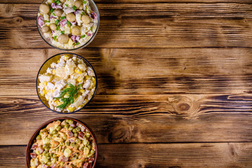 Set of festive mayonnaise salads on wooden table. Top view