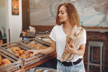 Girl at the bakery. Lady with cake. Blonde in a white shirt