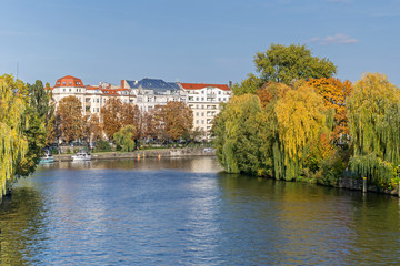 Fototapeta na wymiar Banks of the river Spree with autumn coloured trees and residential buildings at Bundesratufer in Berlin