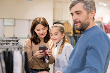 Mother and daughter looking at price of warm knitted gloves for winter season