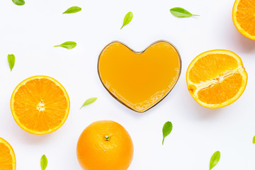 Heart shape glass of fresh orange juice with orange fruit on white background.