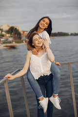 Beautiful girls in a park. Friends have fun in a spring city