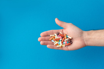 A handful of colored pills on the palm. Medical concept. Shopping at the pharmacy.