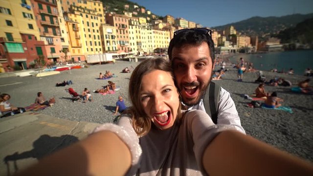 Tourists happy couple taking selfie photo of Camogli, amazing beach near Cinque Terre, Liguria, Italy, Europe. Concept travel.