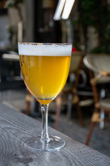Famous Belgian beer served outside in small old cafe in special Belgian beer glass