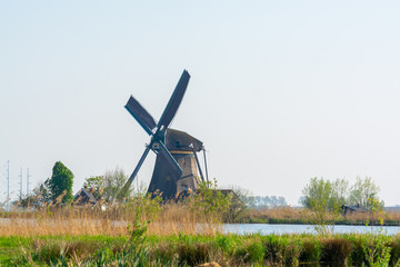 Waterways of North Holland and view on traditional Dutch wind mill, spring landscape