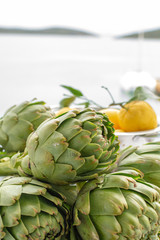 Fototapeta premium Bunch of fresh raw artichokes heads from artichoke plantation in Argolida, Greece ready to cook with lemon