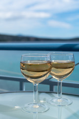 White wine served outside on balcony on glass table with sea view