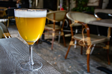 Famous Belgian beer served outside in small old cafe in special Belgian beer glass