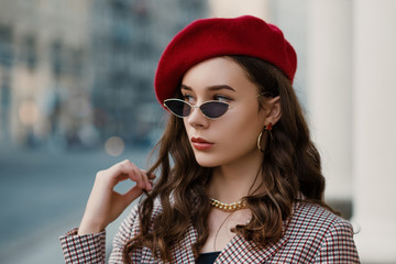 Outdoor close up fashion portrait of young elegant luxury lady wearing red beret, trendy...