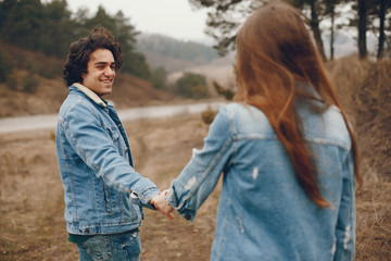 gentle and stylish couple are having a walk in the autumn park