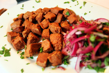 Turkish liver kebab (Ciger Kebab) on the dinner plate