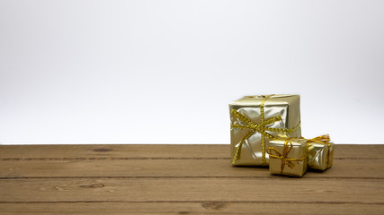 Multiple Wrapped Christmas Holiday Presents in Green Gold and Red Wrapping Paper with Gold Bows on Wood Floor and White Background