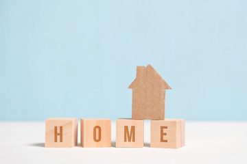 Abstract cardboard house on wooden cubes with the inscription. The concept of a dream about building his house. Close up.