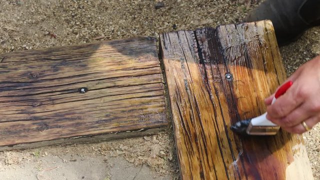 tradesman varnishing outdoor timber edge