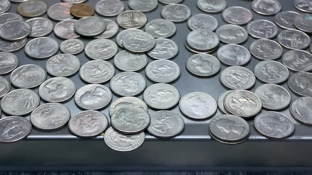 A closeup looping view of quarters in a coin-operated gaming machine. Shot at 60fps.  	
