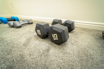 Close up of a pair of iron fixed weight dumbbells with hexagon shaped heads