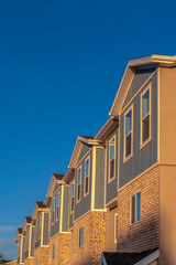 Fototapeta premium Townhomes on a neighborhood with vibrant blue sky background on a sunny day