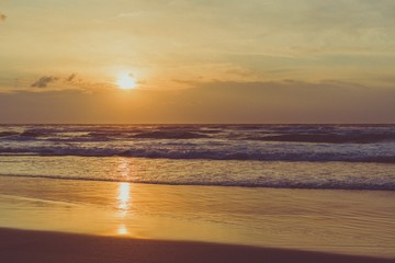 Puesta de Sol en una playa con pequeñas olas
