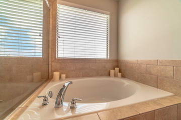 Modern bathroom interior with circular bathtub in front of window with blinds