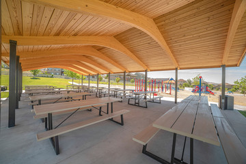Pavilion at a park with view of colorful playground equipment and greenery