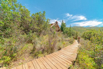 Fototapeta na wymiar Wooden pathway in the mountain for hikers with view of blue sky on a sunny day