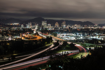 Night cityscape view of traffic on the 5 and 134 freeway interchange near Los Angeles, in Southern California.  Downtown Glendale is in the background.