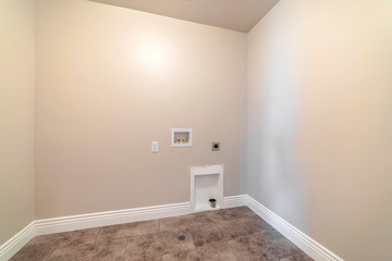 Empty laundry room with water connections empty room