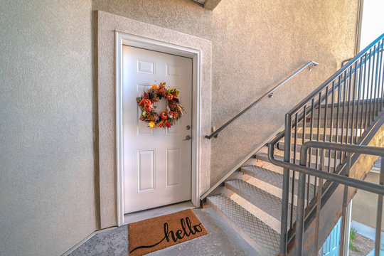 Apartment front door with welcome mat and wreath