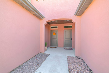 Front doors and porch of modern pink duplex