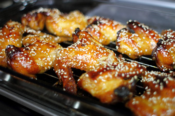 Baked teriayki chicken wings from the oven resting on the stove top in a home kitchen.