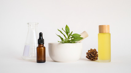 aromatherapy oil with mortar and natural green leaf on white background . aroma skin beauty spa product concept.